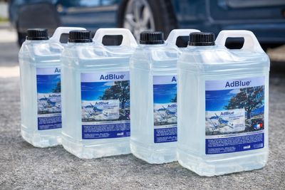 four bottles of airblue on the ground next to a blue car
