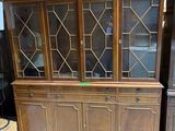 un vaisselier en bois avec des portes vitrées, placé au milieu de la pièce