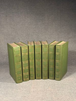 six green books are stacked on top of each other on a gray surface