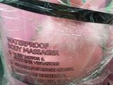 a pink teddy bear in a plastic cup with a black handle