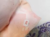 a close up of a person ' s hand holding a pillow with a sticker on it