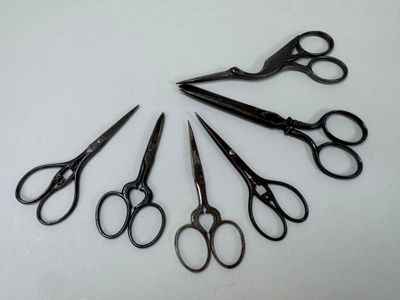 several pairs of scissors are arranged in a circle on a white surface