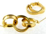 two gold rings on a gold chain on a white surface
