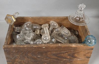 a wooden box filled with glass bottles on a white surface