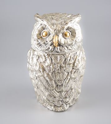 une photo d'une figurine de chouette en argent posée sur une table
