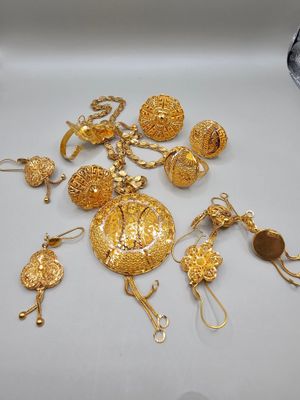 quelques bijoux en or sont posés sur une surface blanche