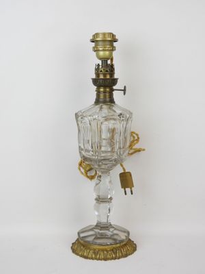 an old fashioned oil lamp with a glass base and gold trimming