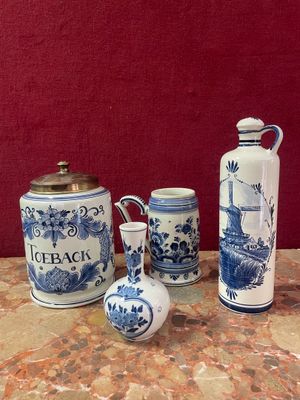 three blue and white vases sitting on a table with a red wall in the background