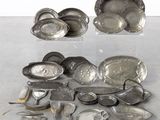de nombreux plats et cuillères en argent posés sur une table