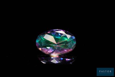 un gros plan d'un diamant coloré sur une surface noire