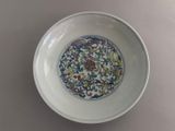 a white bowl with a blue and green design on it