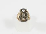gros plan d'une bague en or et diamants sur une surface blanche