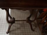 a small table with a wooden top on a tile floor