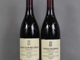 two bottles of wine sitting on top of a table next to each other