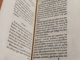 an open book sitting on top of a table next to a wooden table