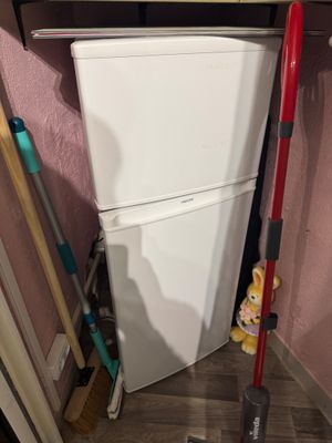 des toilettes blanches et une serpillière rouge dans un coin de la pièce