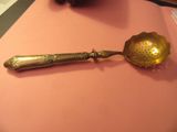 une cuillère et un repose-cuillère posés sur un support rose