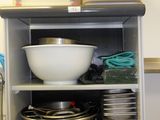 de nombreux bols et casseroles sur une étagère dans la cuisine