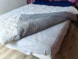 a bed that has a pillow on it in a room