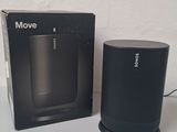 a black box with a speaker sitting next to it on a table