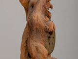 a wooden sculpture of a bear holding a shield