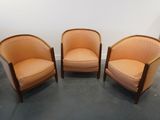 trois chaises orange placées dans une pièce, à côté d'une commode