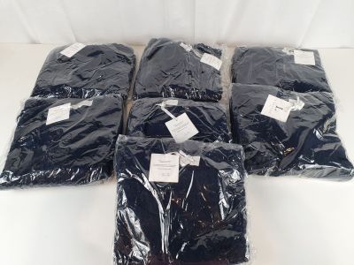 six sacs remplis de t-shirts noirs posés sur une table blanche