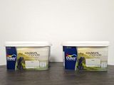 two tubs of yogurt sitting on top of a wooden table