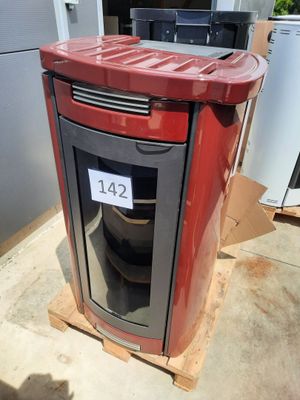a red stove sitting on a pallet in front of a refrigerator