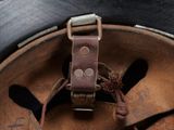 a close up of a helmet with a leather strap on it
