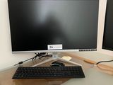 un écran d'ordinateur et un clavier posés sur un bureau, devant un écran