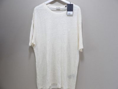the white shirt is hanging on a hanger on the wall