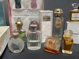 many bottles of perfume sitting on a table next to each other
