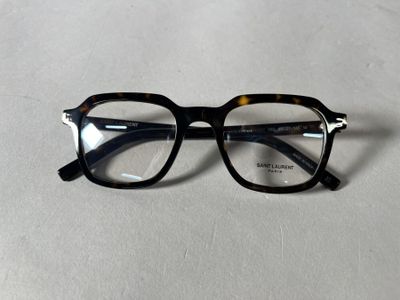 des lunettes noires et écaille posées sur une surface blanche, sur fond blanc