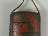 a brown and red case with a bow on it