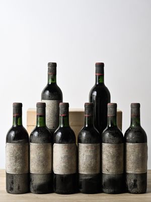several bottles of wine are lined up on a wooden table