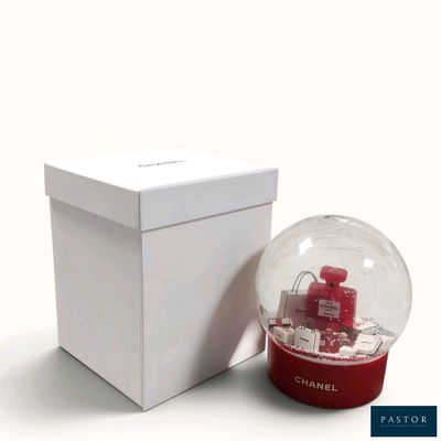 a snow globe sitting next to a box on a white surface