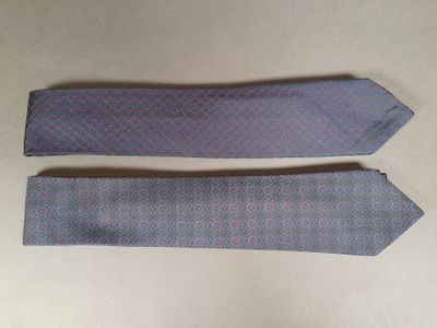 two ties are laying on a table next to each other