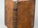 un vieux livre posé sur une surface blanche