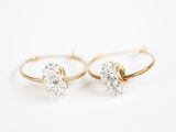 une paire de boucles d'oreilles en or et diamants sur fond blanc