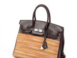 a brown and orange striped handbag sitting on top of a white surface