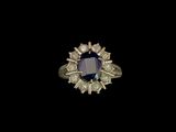 gros plan d'une bague avec une pierre bleue entourée de diamants