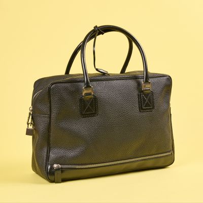sac à main en cuir noir sur fond jaune, avec un espace réservé au texte