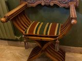une chaise en bois sur laquelle est posé un coussin rayé