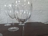 several empty wine glasses sitting on a table with a white wall in the background