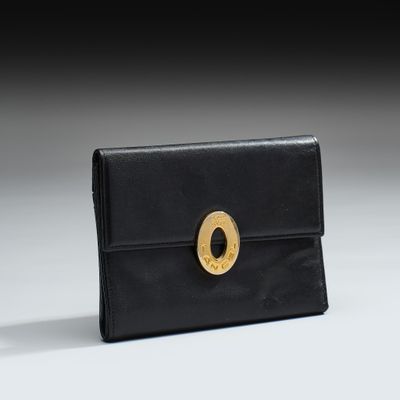 une image représentant un sac à main noir orné d'un anneau doré