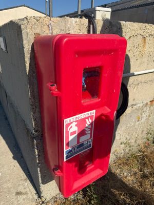 une borne d'incendie rouge posée au bord de la route