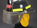 firefighter ' s helmet on a mannequin head with a yellow face mask