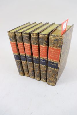 cinq livres sont empilés les uns sur les autres sur une surface blanche