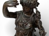 bronze statue of a woman holding a bird in her hand